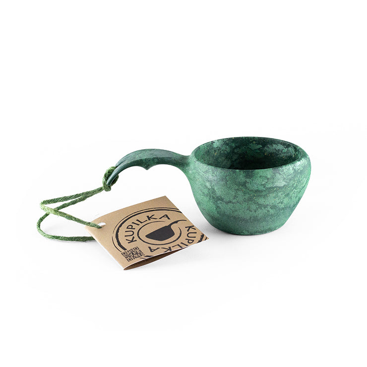 a green vase with a green plant in it