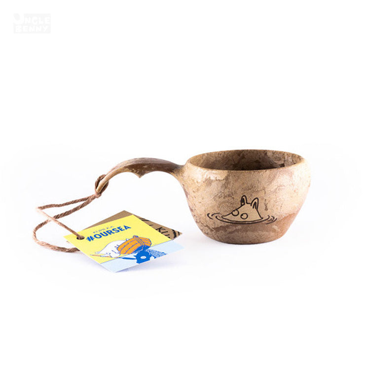 a coffee mug sitting on a table next to a cup