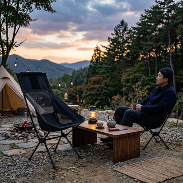 日韓美學露營營地夕陽下放置於草地上的黑色 Helinox 高背戰術折疊椅